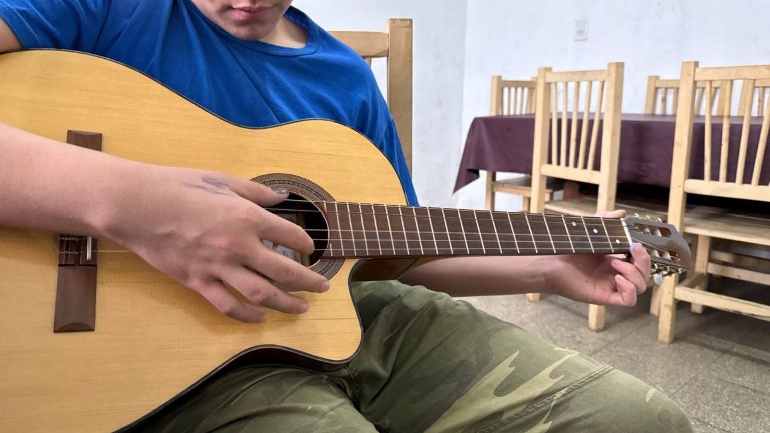 Con su guitarra, obsequio de cumpleaños, toca melodías de oído